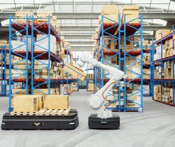 Automated Robot Carriers And Robotic Arm In Modern Distribution Warehouse Automation with AGV and robotic arm in modern distribution warehouse.
